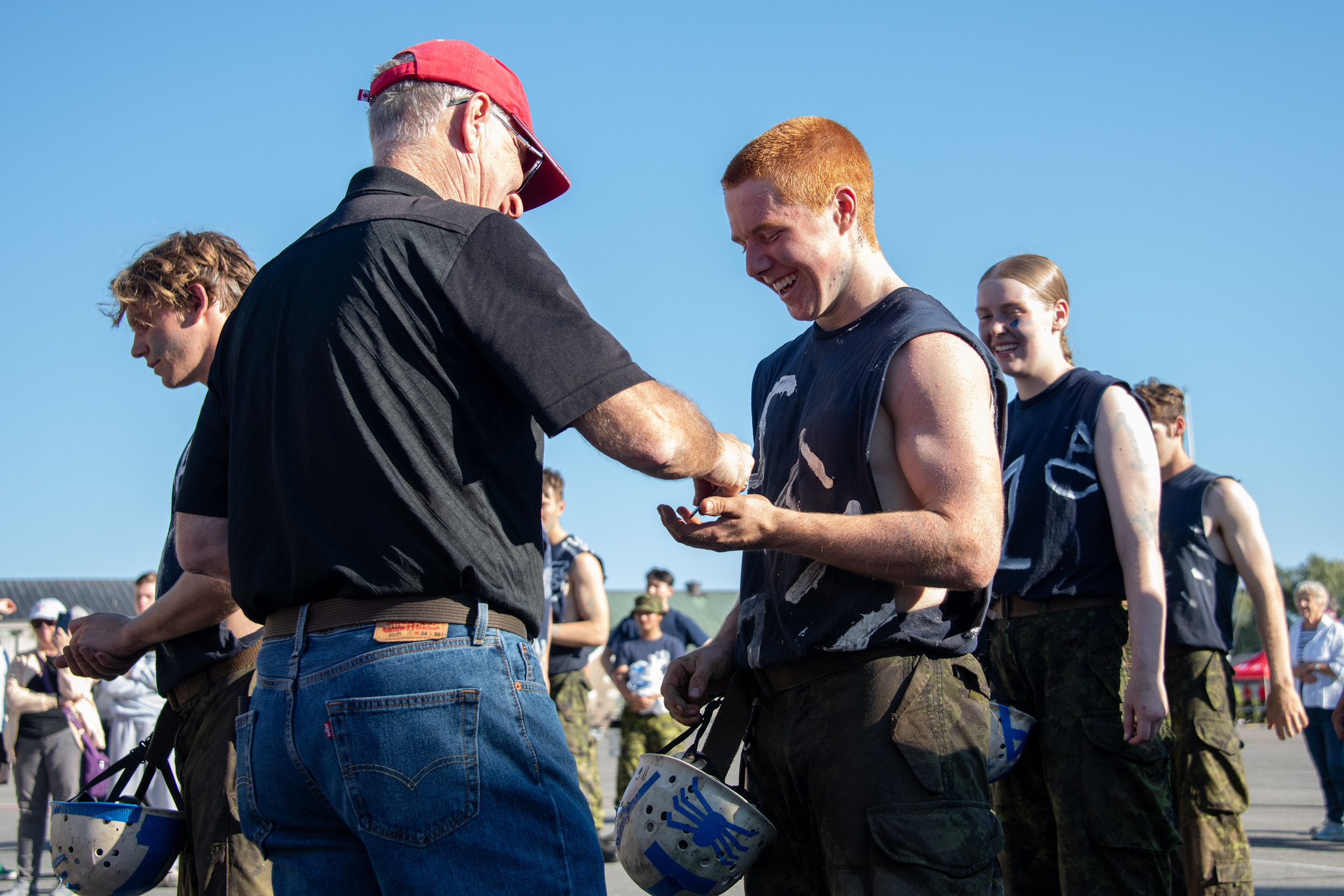 A member of the 'old Brigade' give a cadet the coin bearing his College Number 