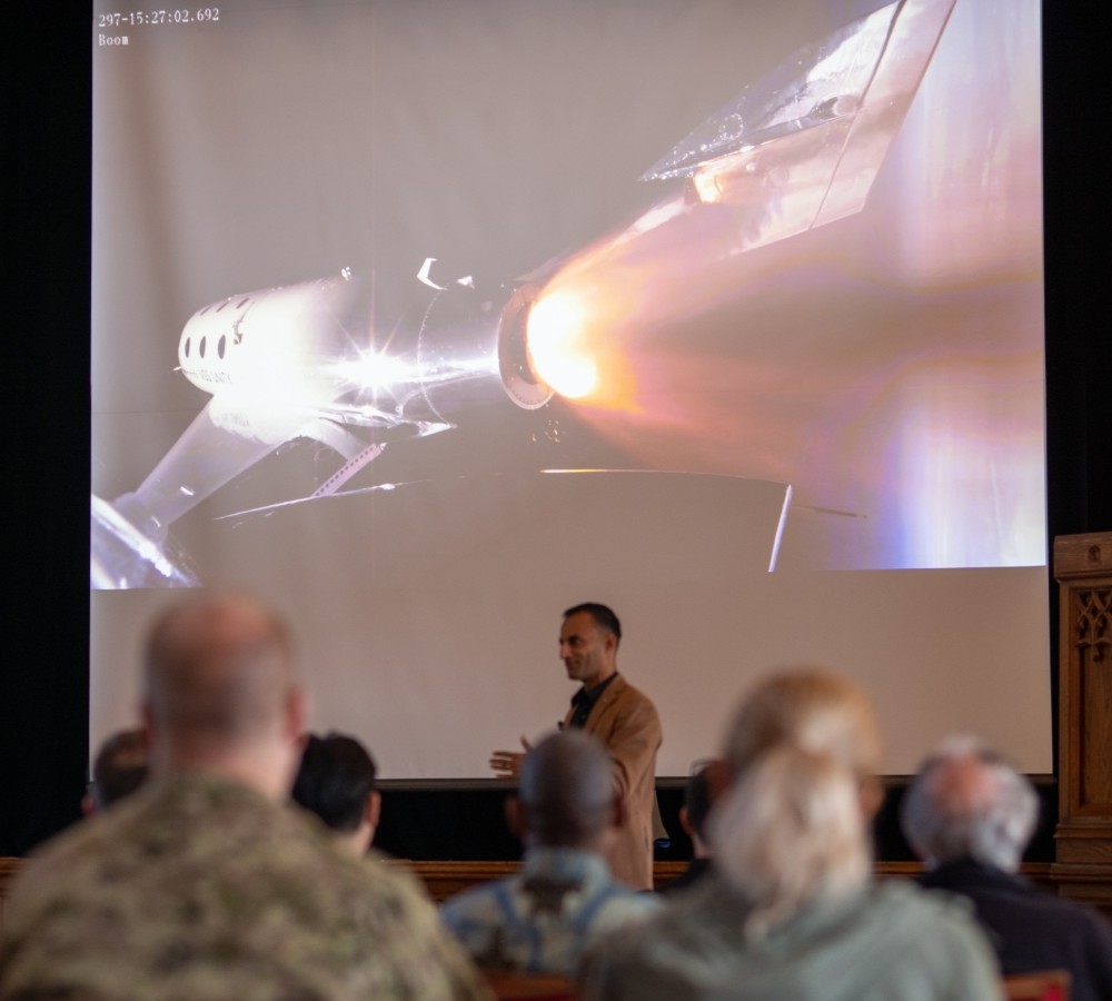 Maj (Ret) Janjua, with video from the June 2024 Virgin Galactic mission in the background, talks about the experience of going into space.